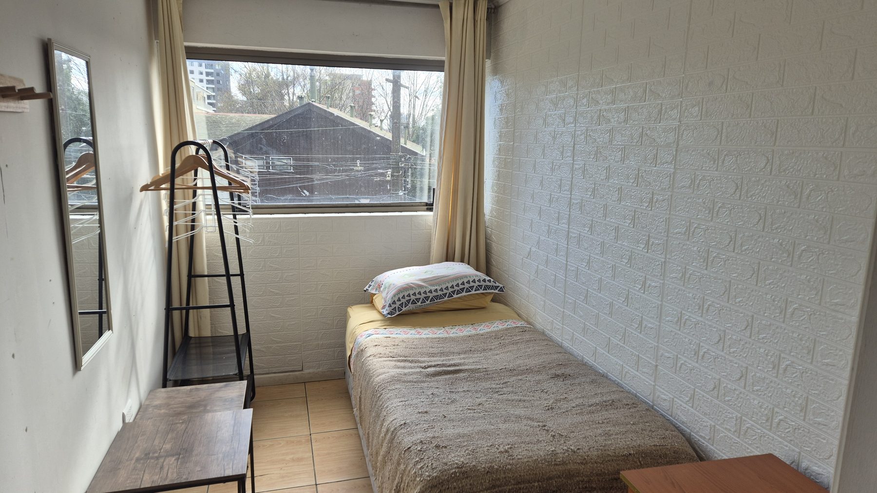 Habitación individual con escritorio y ventana