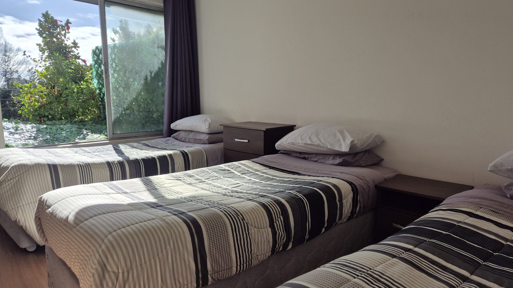 Habitación triple con camas separadas y vista al jardín
